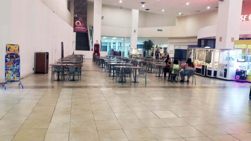 Un par de personas en el patio de comidas, el resto vacío