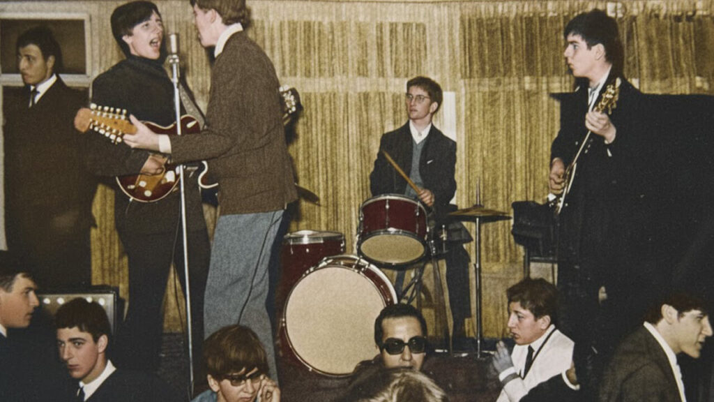 Charly García con su primera banda de espaldas con una guitarrra de doce cuerdas
