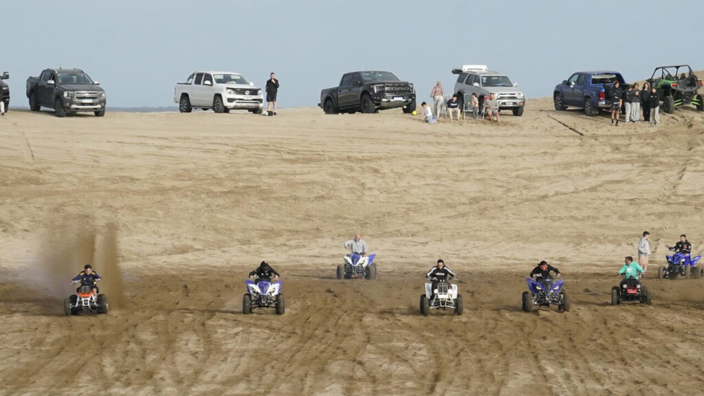 Gente grande haciendo picadas con cuatriciclos, al menos tienen el público detrás