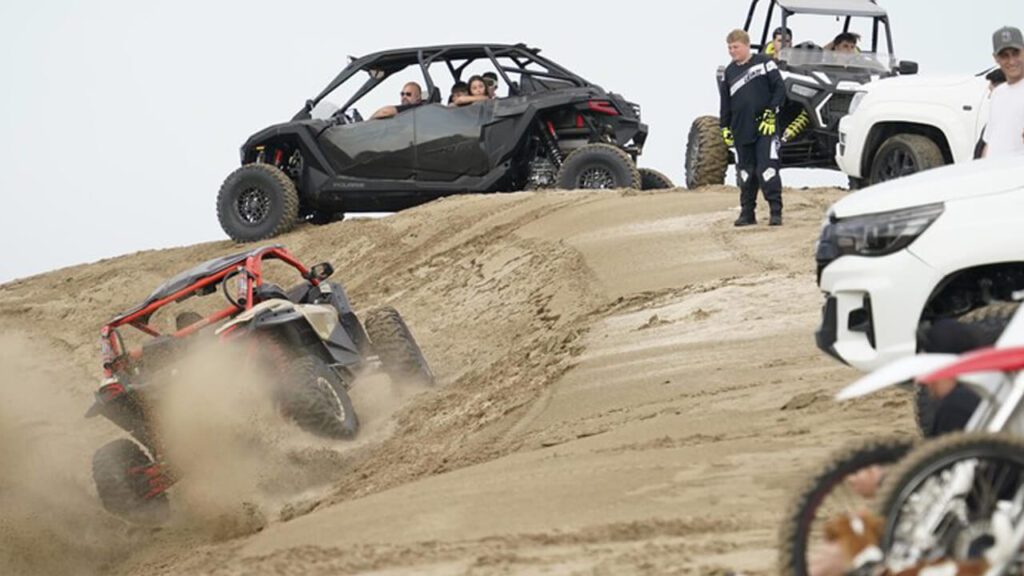 Un UTV trepa y trepa rodeado de otros vehículos y gente sin hacerse ningún problema