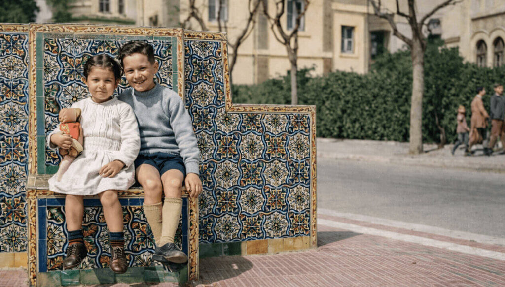 Dos niños pasan en la Plazoleta frente a la Casona de Manuel Fresco en Haedo Norte sobre los asientos del Patio Andaluz (Foto Coloreada)