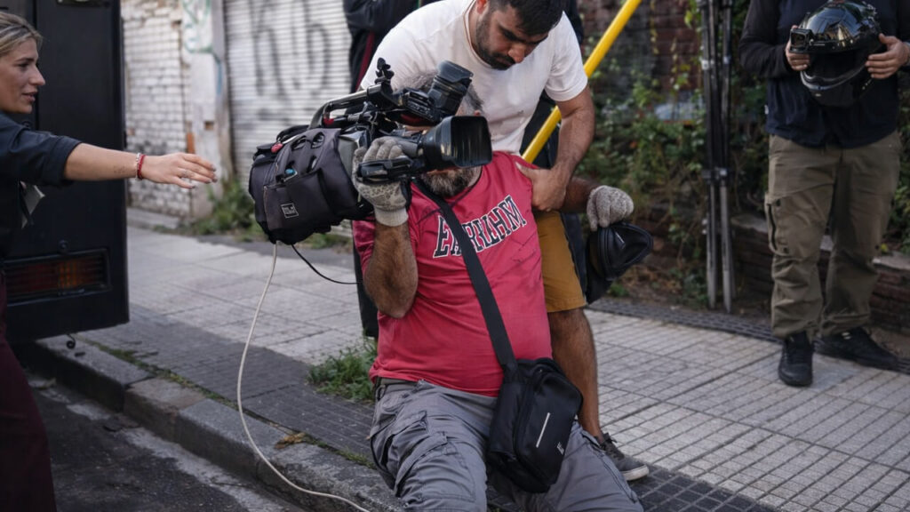 El cámara de A24 intentando reponerse luego de que la policía lo empujara y cayera al piso