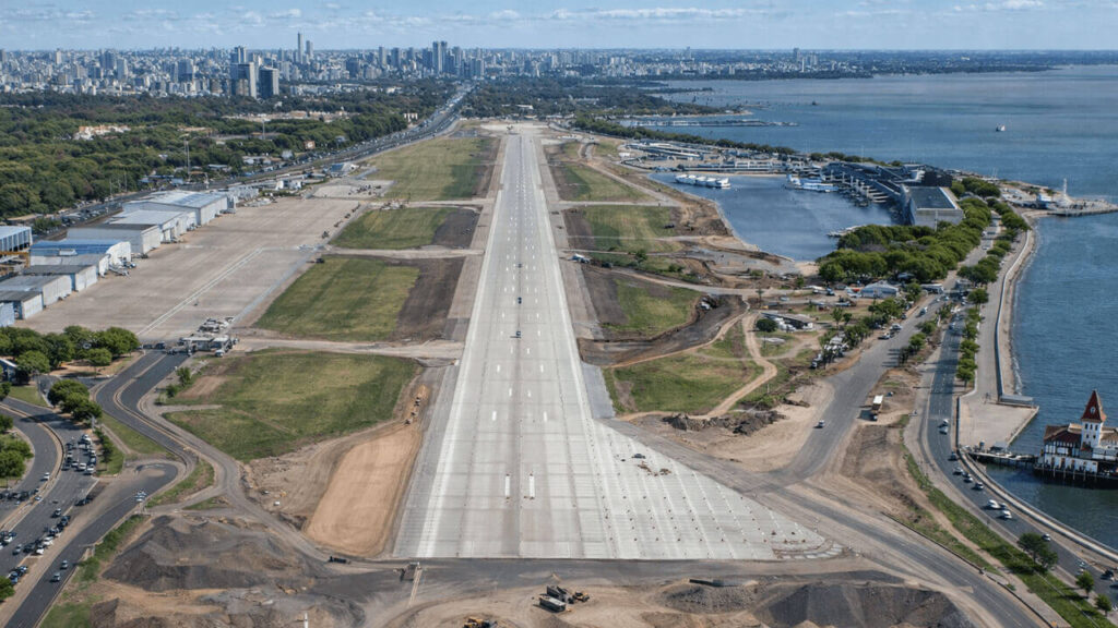 En construcción la ampliación de la pista hecha sobre terrenos ganados al Río de la Plata, más allá la Ciudad Universitaria, y luego la Ciudad de Buenos Aires