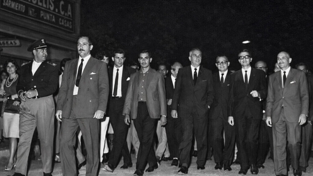 Abel Costa, en segundo plano, recorre Morón de noche y justo pasa por la Inmobiliaria De Angelis