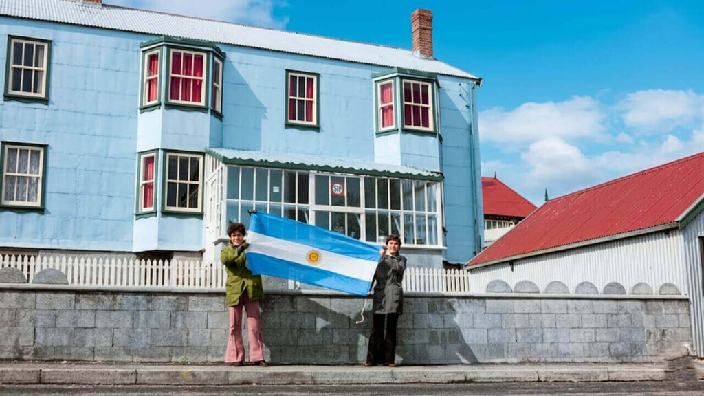 Dos habitantes o dos turistas, no pudimos saberlo, depliegan la bandera argentina en las Islas Malvinas