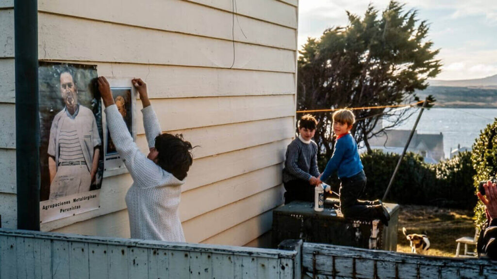 Una mujer pega un afiche de Perón y de Evita contra su casa sin que nadie se inmute en las Islas Malvinas