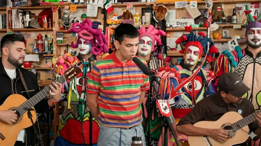 Milo J canta en el Tiny Desk  con el banderín de Deportivo Morón al frente, sobre el soporte del micrófono