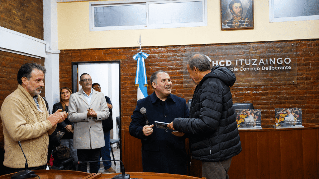 El Presidente del Concejo Deliberante de Ituzaingó, Juan Manuel Alvarez Luna, recibe un obsequio por organizar la charla y sostener la muestra 