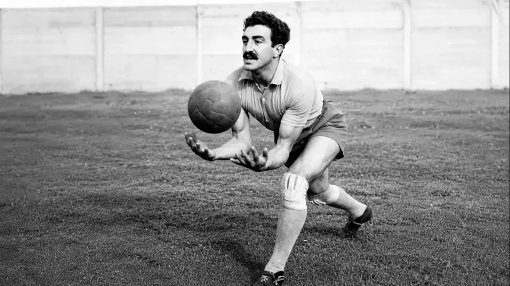 Miguel Ángel Rugilo posando mientras recibe una pelota en sus brazos trabajados