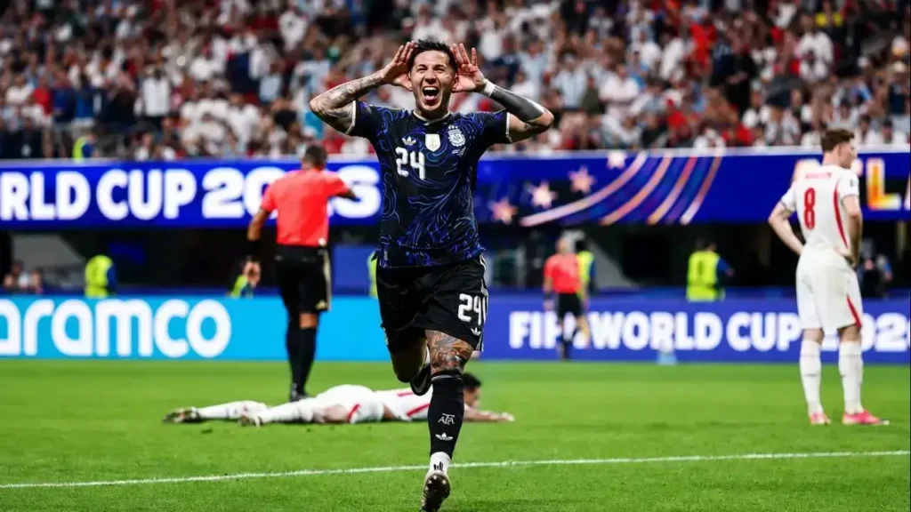 Enzo Fernández, con la camiseta 24, corre hacia la tribuna con las manos en los oídos para celebrar el gol del empate de la Selección Argentina. Detrás suyo, Elliot Anderson (8) permanece de pie mientras otro futbolista de Inglaterra queda tendido sobre el césped, reflejando el impacto del potente remate que dejó sin respuesta a Jordan Pickford y cambió el rumbo de la semifinal.