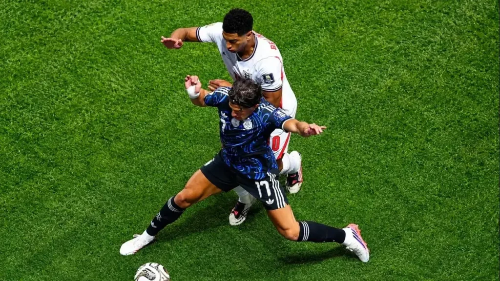 Giuliano Simeone protege la pelota con el cuerpo y le gana la posición a un defensor de Inglaterra durante una intensa disputa individual. El delantero argentino volvió a exhibir su despliegue físico y su entrega en la victoria que clasificó a la Selección Argentina a la final del Mundial 2026.