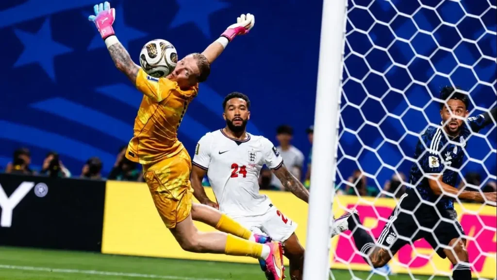 Jordan Pickford vuela, pero no consigue contener el potente remate de Enzo Fernández, que se convierte en el gol del empate para la Selección Argentina. Reece James sigue la trayectoria de la pelota desde el área, mientras Lautaro Martínez acompaña la jugada en el segundo palo durante una de las acciones decisivas de la semifinal ante Inglaterra.