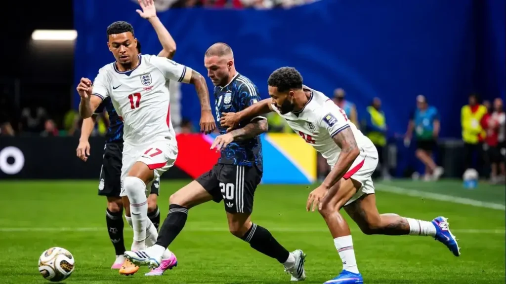 Alexis Mac Allister intenta salir jugando entre la presión de Curtis Jones (17) y Reece James, que cierran espacios para recuperar la pelota en una intensa disputa por el mediocampo durante la semifinal entre la Selección Argentina e Inglaterra.
