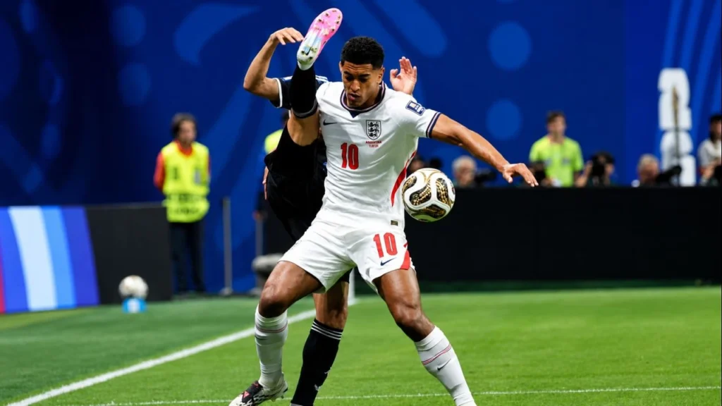 Jude Bellingham (10) protege la pelota y resiste la presión de un futbolista de la Selección Argentina en una intensa disputa por la posesión durante la semifinal del Mundial 2026 entre Inglaterra y Argentina.