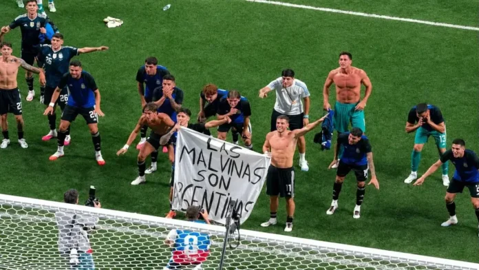 La imagen de los jugadores de la Selección Argentina desplegando una bandera con la inscripción 