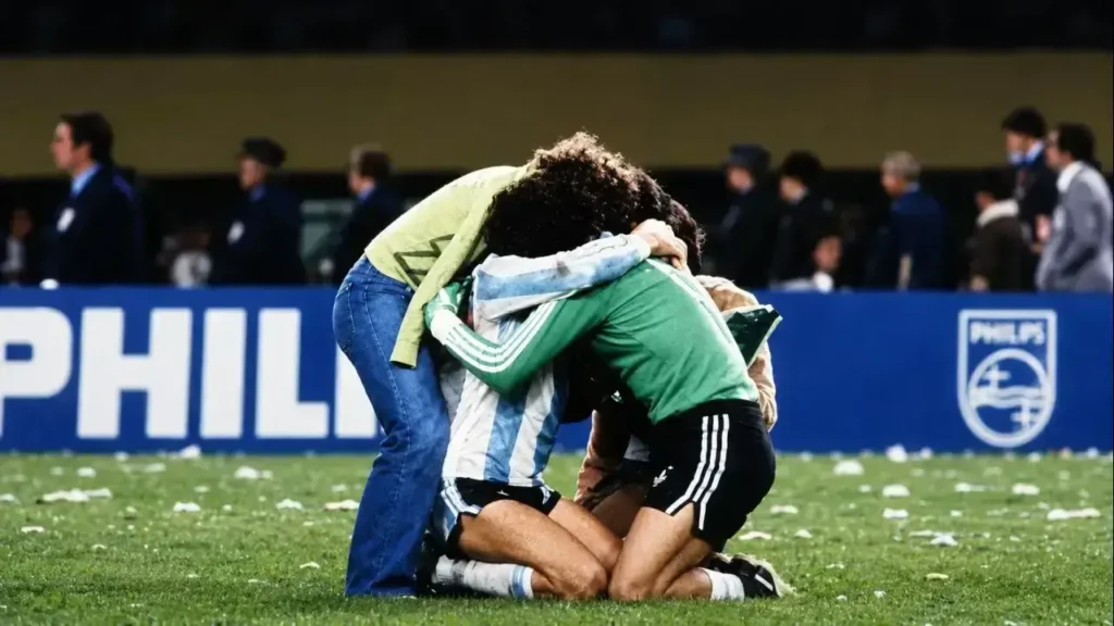 Víctor Dell’Aquila va al encuentro del arquero Ubaldo Fillol y Alberto Tarantini que se funden en un abrazo emotivos tras vencer a Países Bajos en la final del Mundial 1978, disputada en el estadio Monumental el 25 de junio de 1978. Fillol llamó a ese abrazo, El Abrazo del Alma.