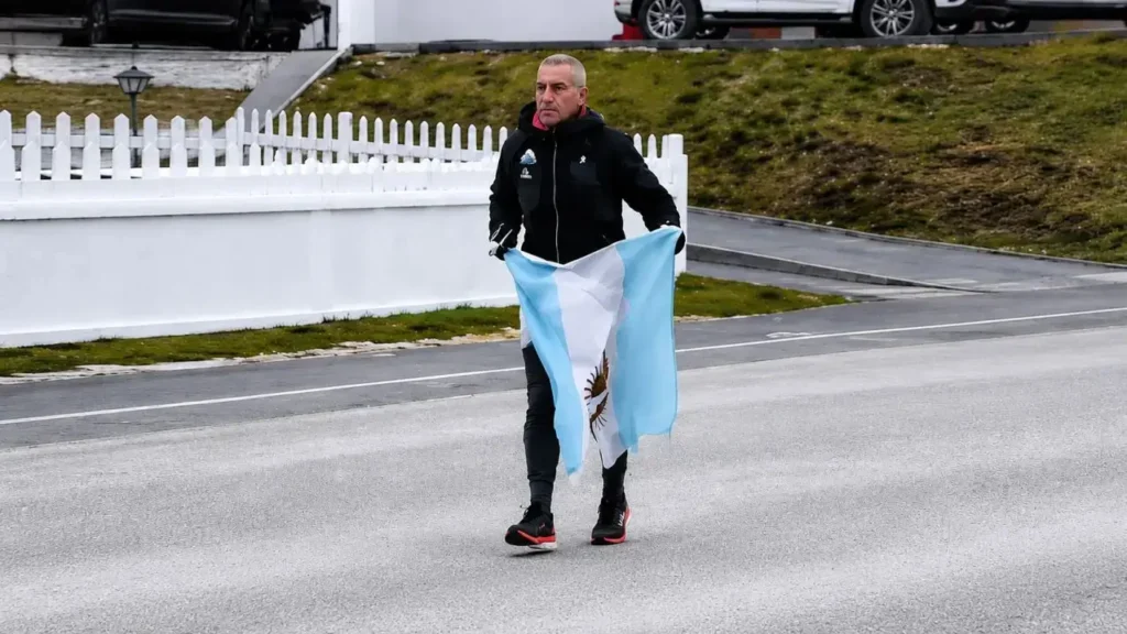 Eduardo Canitrot corre por Puerto Argentino con una bandera Argentina en conmemoración de sus compañeros caídos.