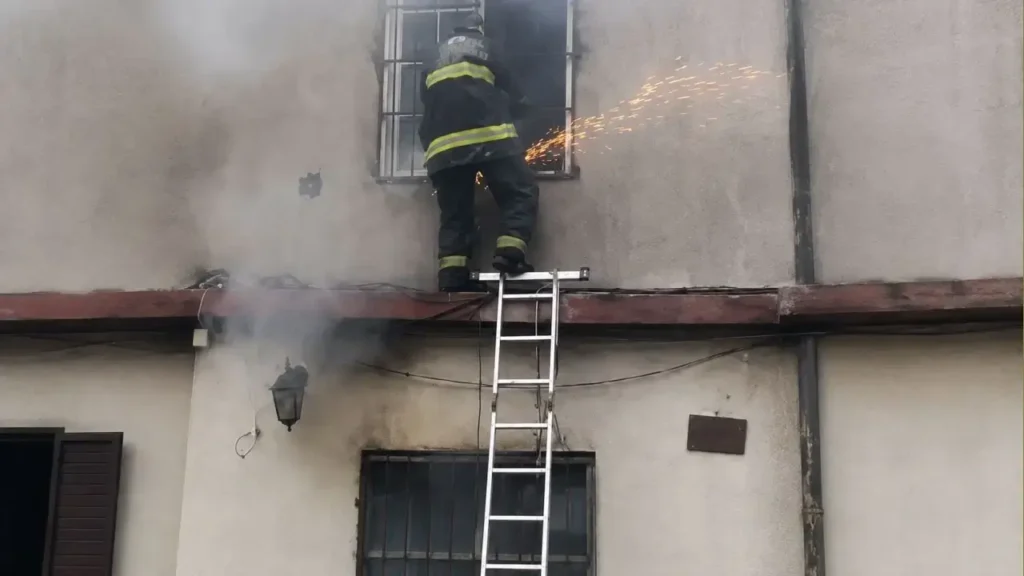Lo Bomberos Voluntarios de Ituzaingó ingresan al primer piso con luego de cortar una venta con una amoladora. Gran trabajo.