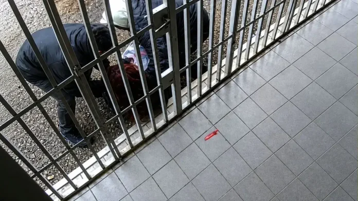 La mujer en el piso luego de ser atacada por dos jóvenes es asistida por una pareja adulta que pasaba caminando.