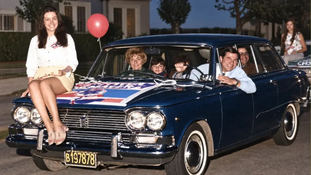 La Reina de la Primavera a bordo del automóvil de Perfumería Karina. El local estaba ubicado sobre la avenida Arias, a metros de Carlos Casares y pegado al histórico bodegón Santa Anita. En los años 80, sobre una torre en desuso que la perfumería tenía en el techo, FM En Tránsito montó la antena para realizar sus primeras transmisiones, que aún hoy continúan.