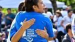 Una participante con la remera de la "Familia Grande Hogar de Cristo" comparte un momento emotivo en un encuentro comunitario.