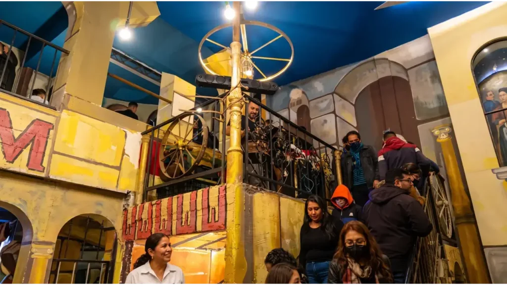 Clientes y personal en el interior de la confitería, decorada con arcos, murales y detalles de ambientación romana.