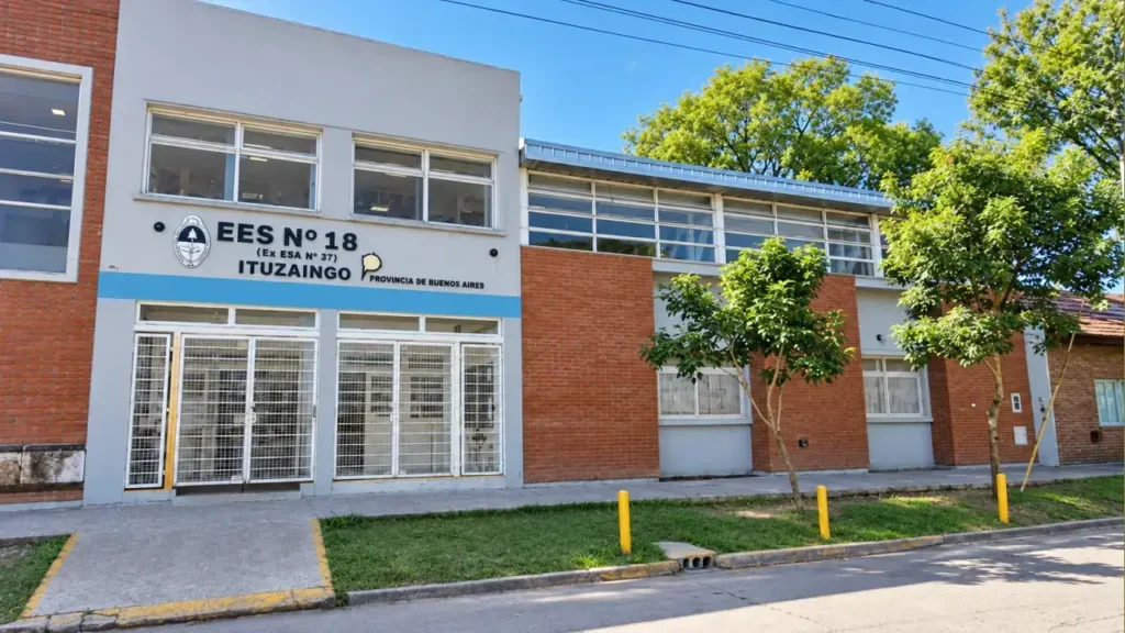 La imagen muestra el frente de la Escuela de Educación Secundaria Nº18 - Ituzaingó (ex Escuela de Educación Media/Adultos Nº 37), un establecimiento educativo público de nivel secundario dependiente de la Dirección General de Cultura y Educación de la Provincia de Buenos Aires. Esta ubicada en General Pinto 1754, entre Olazábal y Monroe, localidad y partido de Ituzaingó.