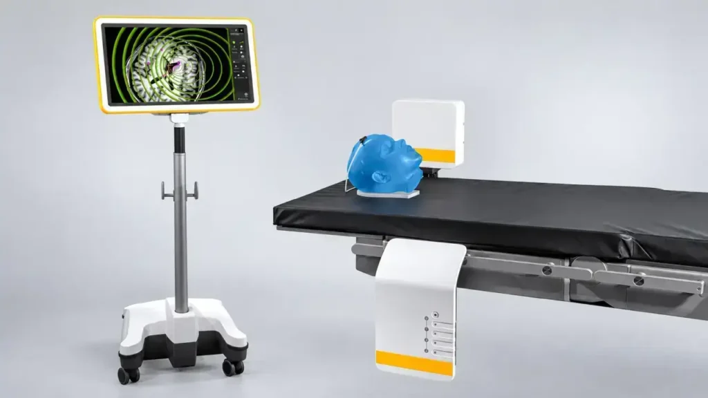 Muestra el dispositivo de referencia y seguimiento espacial junto a un maniquí de entrenamiento clínico, utilizado para calibrar y demostrar el sistema que guía el instrumental dentro de la cabeza de la paciente, logrando que el equipo opere a ciegas en profundidad con precisión submilimétrica.