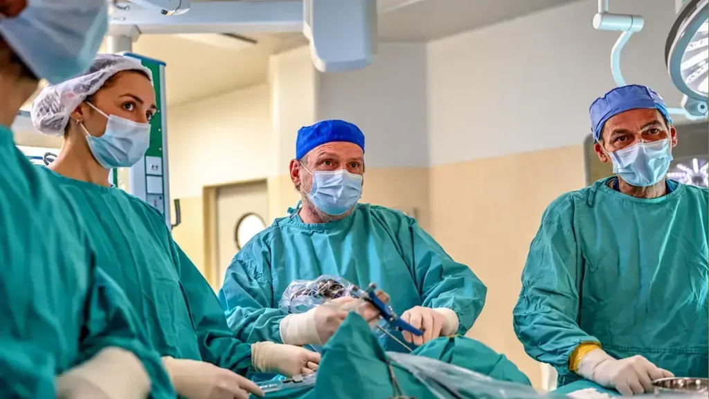 Muestra el trabajo conjunto del equipo de neurocirugía, anestesiología y enfermería quirúrgica durante la fase crítica del procedimiento, logrando mantener la estabilidad hemodinámica de la paciente y el control visual continuo en pantalla para asegurar una resección segura y sin sangrados imprevistos.