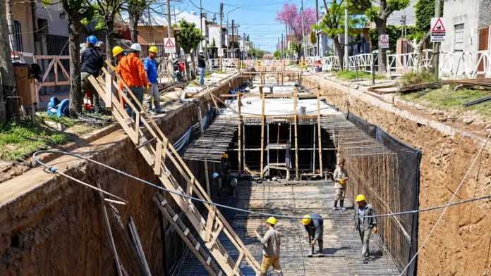 La obra del Arroyo Dupuy avanza en plena trama urbana, entre viviendas y calles del partido de La Matanza. La excavación, las armaduras de hierro y los encofrados forman parte del conducto hidráulico incluido en un proyecto adjudicado por más de $59.000 millones, que busca mejorar el escurrimiento y reducir el impacto de las inundaciones.